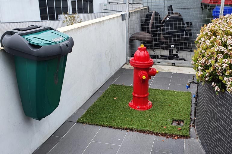 Red fire hydrant on astro turf for both guide and support dogs Toileting